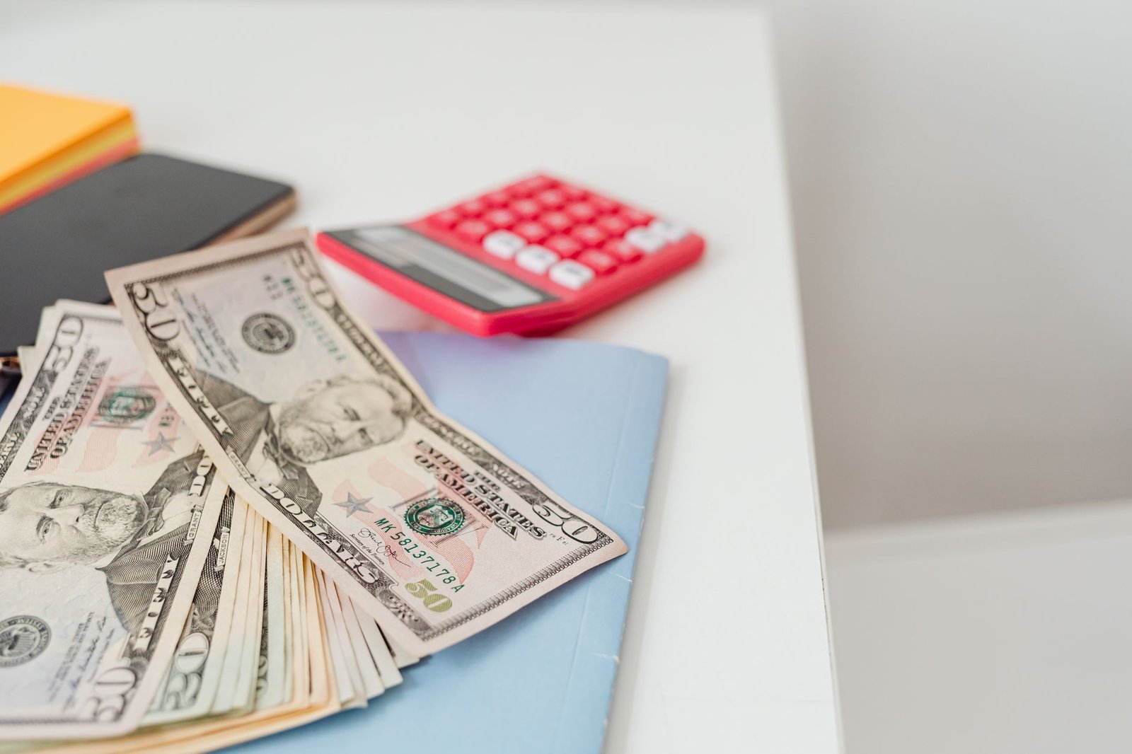 US dollar bills, a notebook and a calculator on a desk illustrating AI cost budgeting