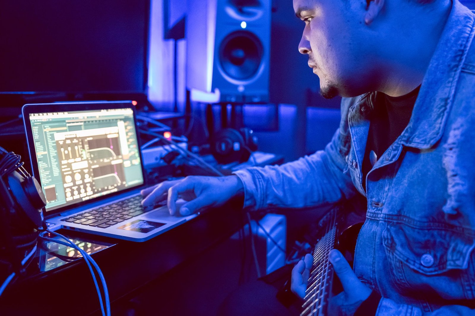 Musician using a laptop in a recording studio while producing music