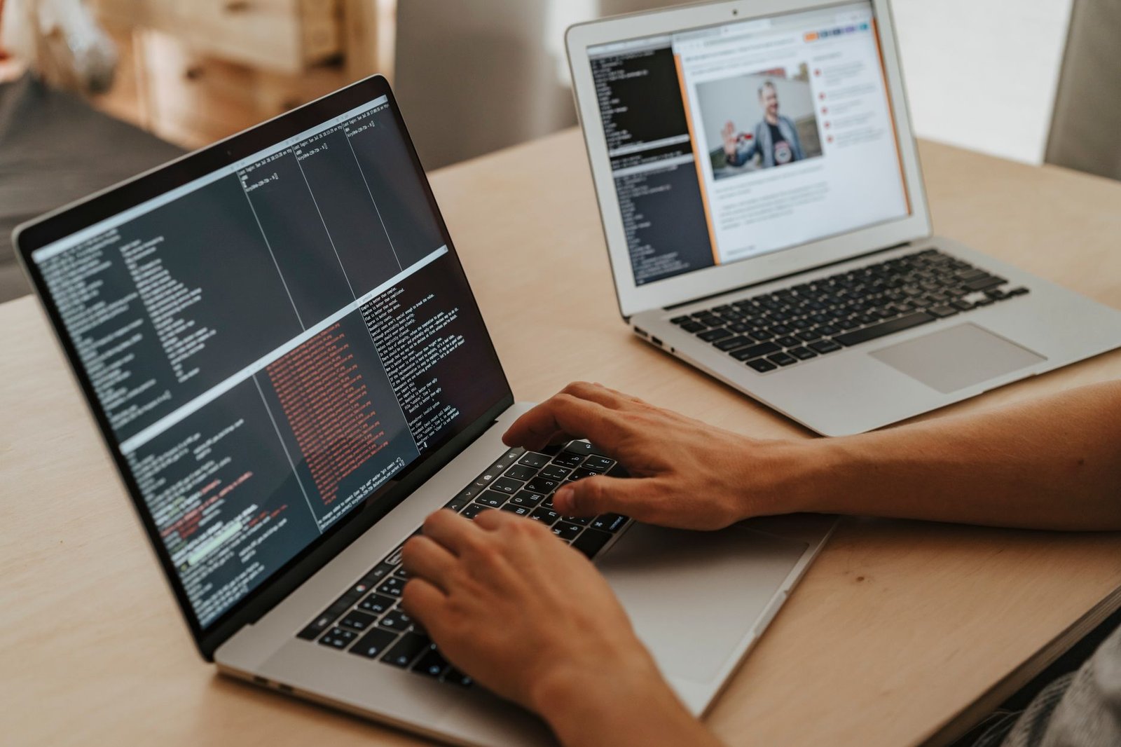 A developer working and typing code on a laptop