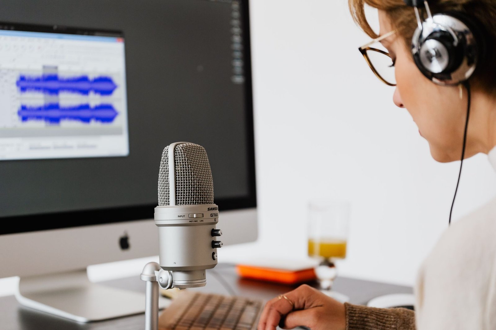 Person using a microphone and headphones for AI voice recording work with ElevenLabs