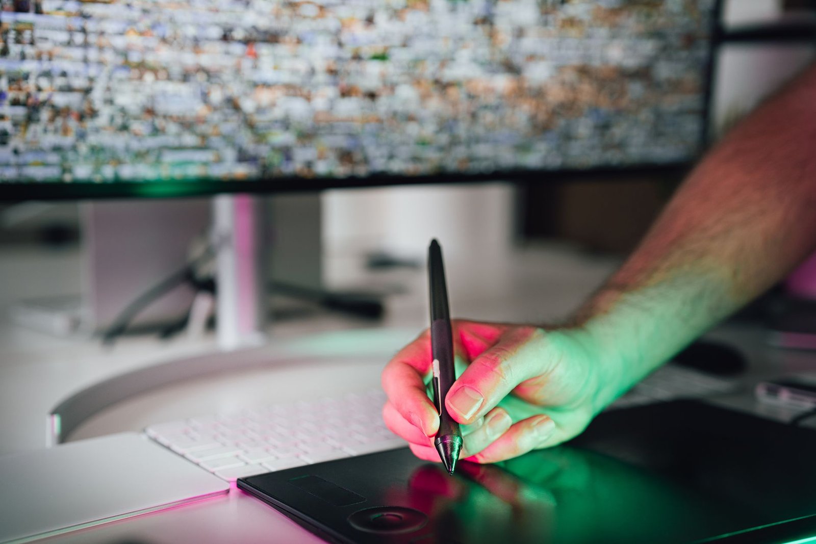 Digital artist using a graphics tablet and stylus in a modern workspace