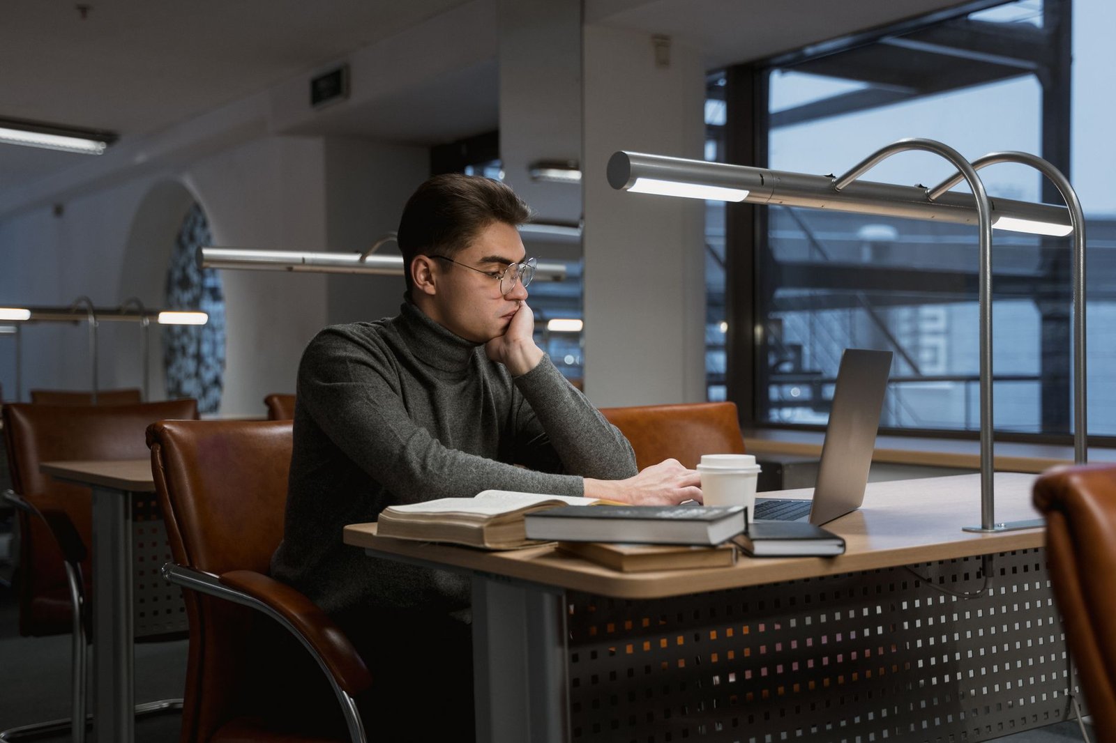 Person focused on a laptop doing research, the core use case for NotebookLM