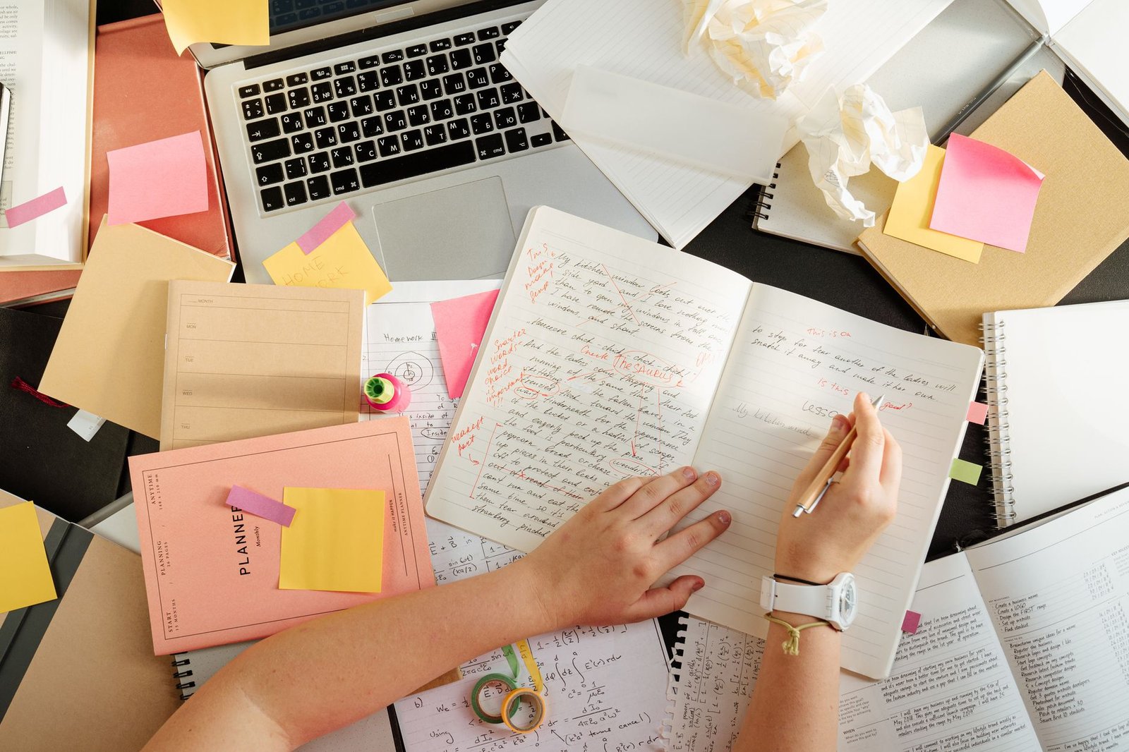 Many research documents and notes spread across a desk, the kind of material NotebookLM organizes
