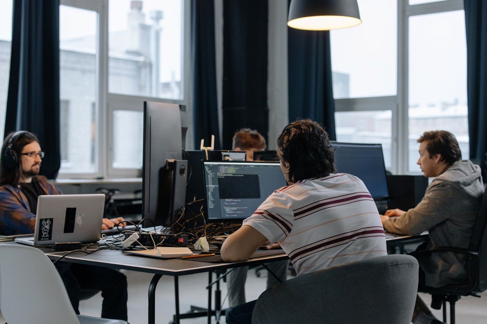 Team of enterprise developers coding on computers in a modern software office