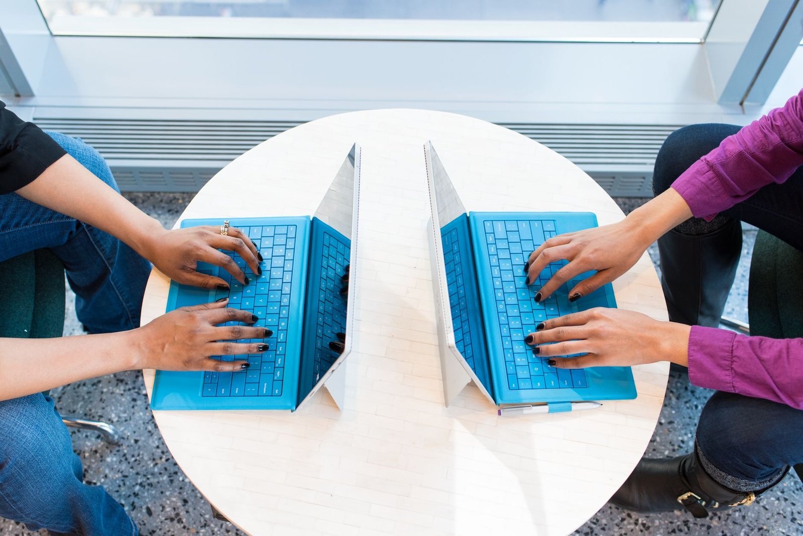 Two people testing workspace AI tools on laptops at a table