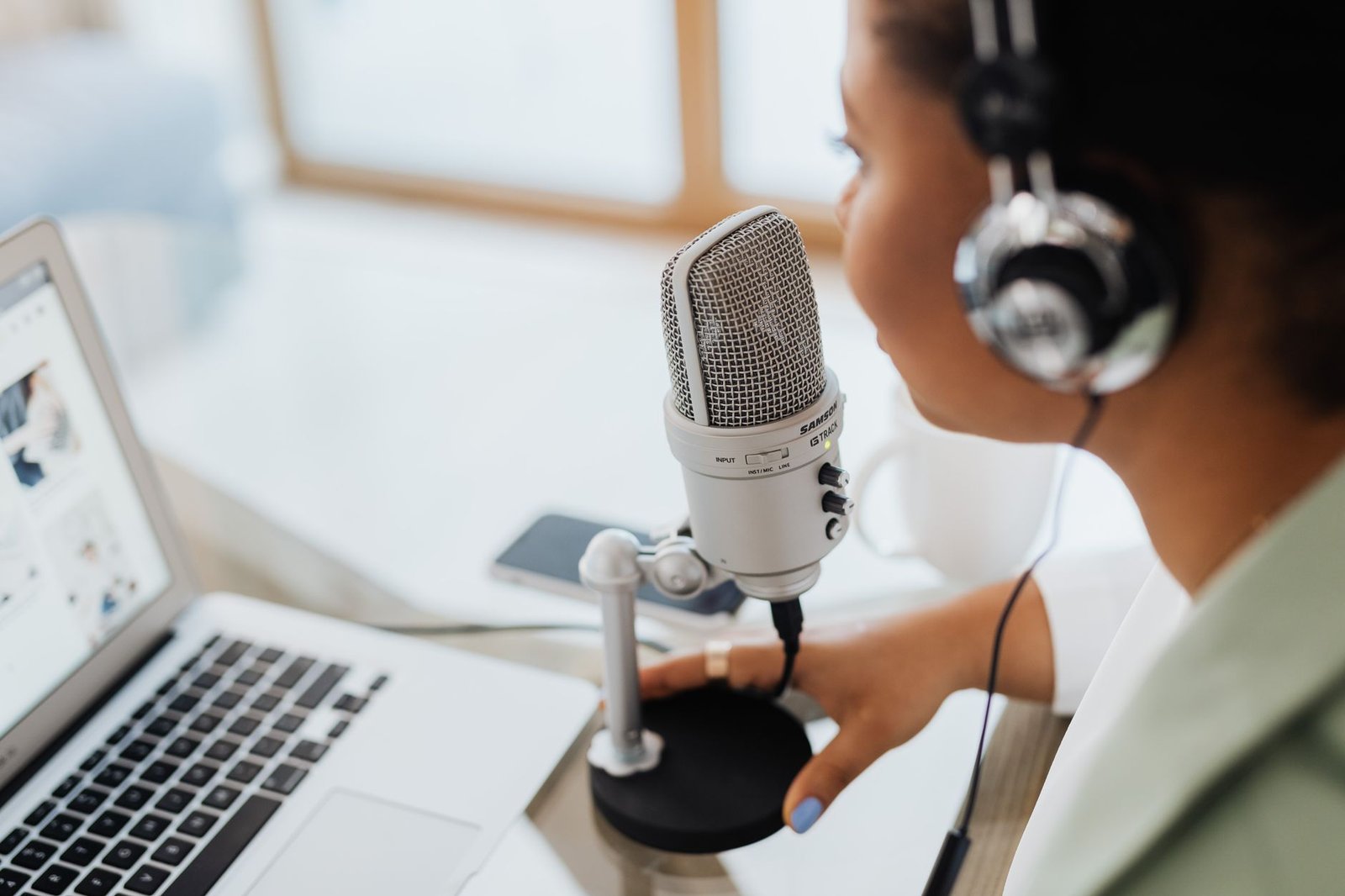 Person dictating into a microphone at a desk using AI speech-to-text